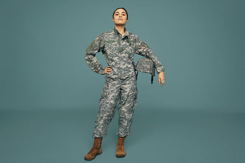 Female army soldier standing strong in a studio