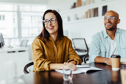 Happy business people sitting in a meeting in an office