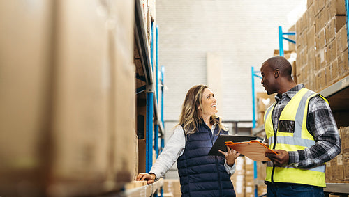 Happy warehouse colleagues having a discussion