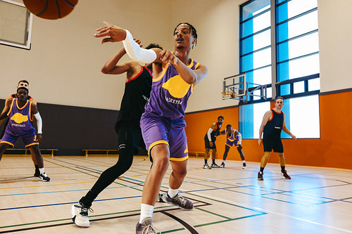 Basketball players competing in an intense basketball game