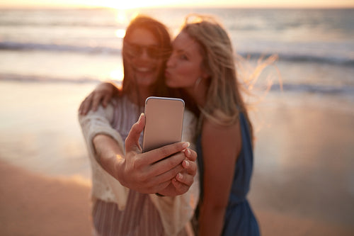Woman friends taking selfie at the beach