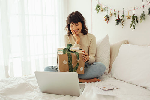 Smiling woman on a video call showing her christmas present