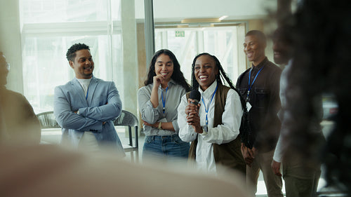 Woman speaks to diverse group smiling