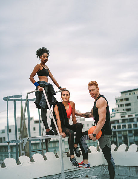 Fitness people relaxing after workout on rooftop