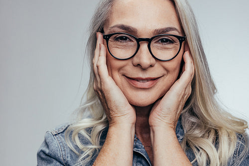 Senior woman with hands on cheeks