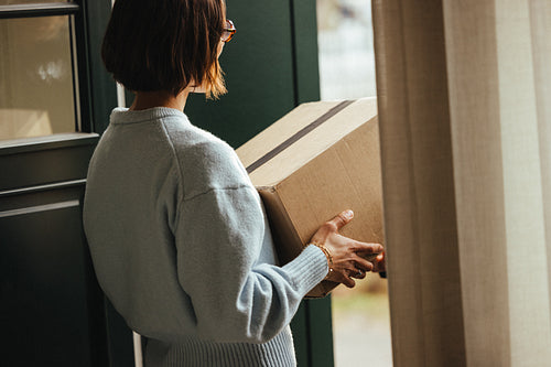 Home delivery: woman receiving a package from courier