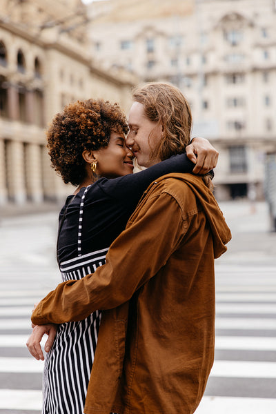 Embraced lovers sharing a moment on a city crosswalk