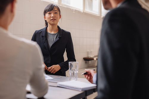 Businesswoman interacting with colleagues during presentation