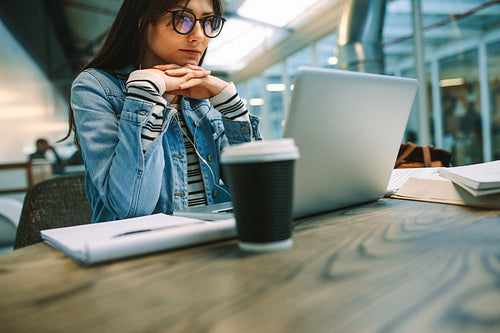 Woman student reading information on laptop