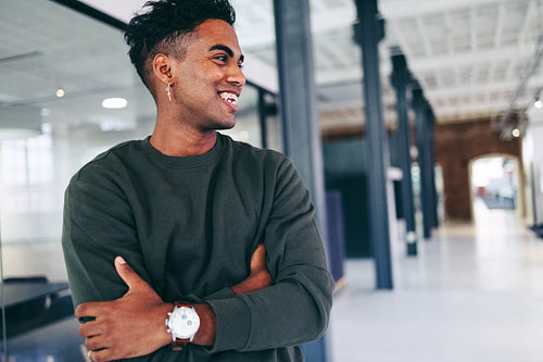 Modern businessman smiling cheerfully while standing in an office