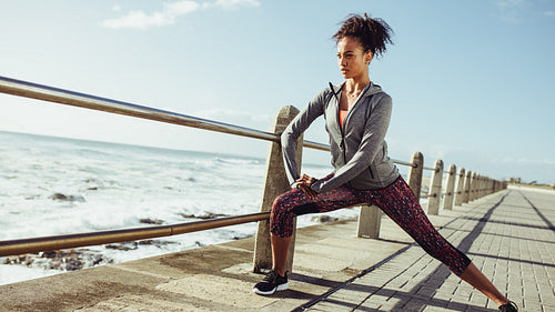 Woman stretching at seaside promenade