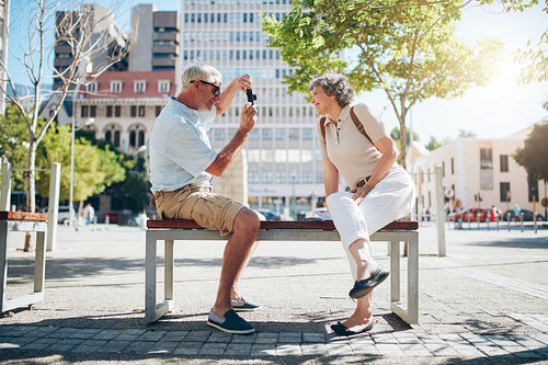 Senior man taking pictures of his wife