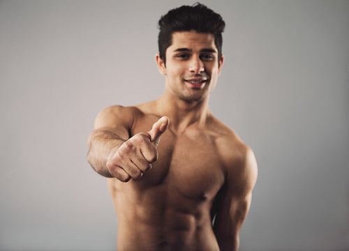 Happy bodybuilder showing thumbs up sign