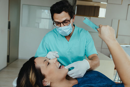 Female patient receives care as the dentist performs a routine dental exam in the clinic