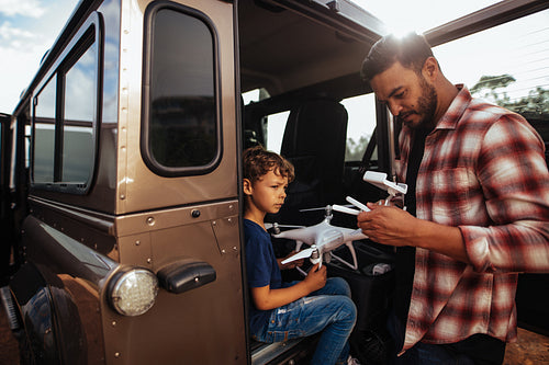 Father and son setting up a drone on road trip