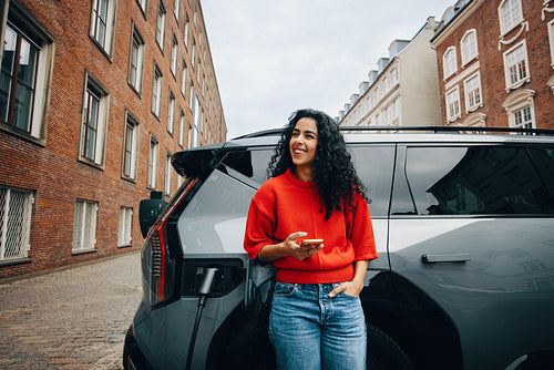 Young woman finds city charging station using smartphone app