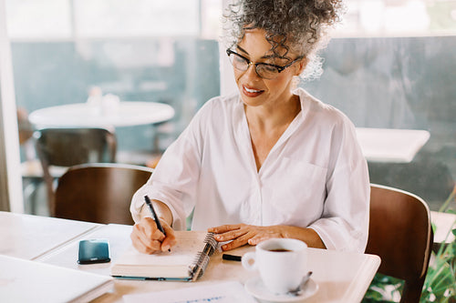Businesswoman writing notes in her journal