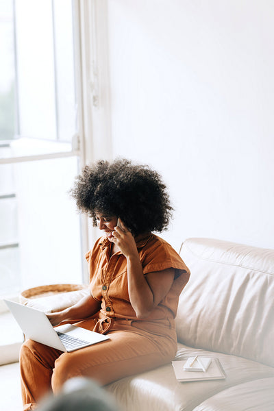 Happy young businesswoman speaking on the phone in an office lobby