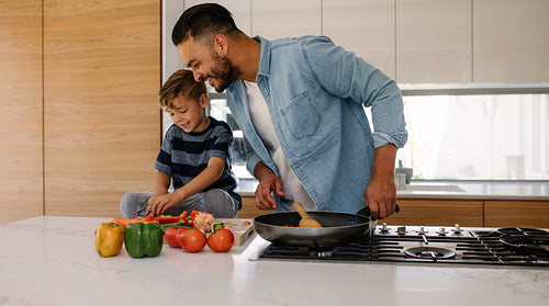 Father and son cooking together in kitchen
