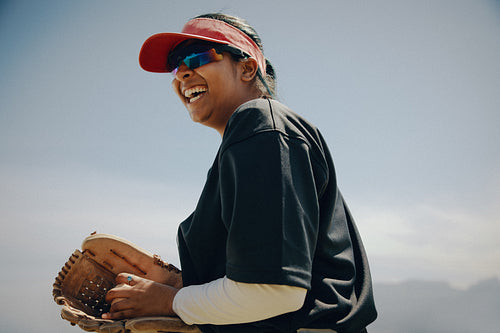 Smiling baseball pitcher with enjoying a sunny day on the field