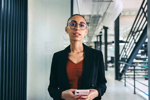 Young businesswoman holding a smartphone in an office