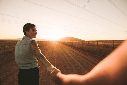 Couple walking hand in hand on highway