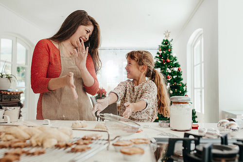 Mother and daughter having fun while making Christmas cookies.