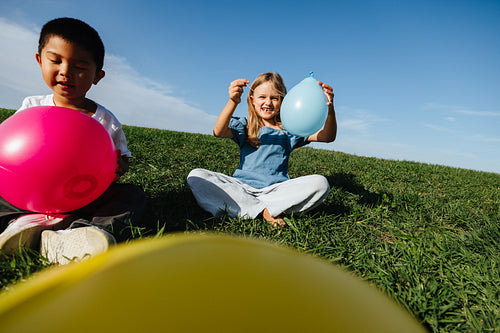 Children playing with balloons in a park