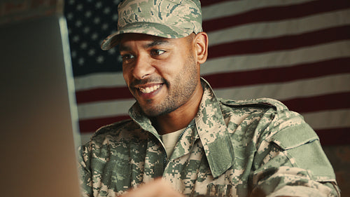 Connecting with family from the army: US soldier having a video call on a laptop