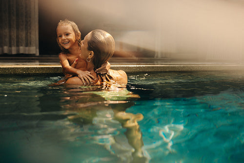 Mother and son enjoying a swim in the pool during vacation