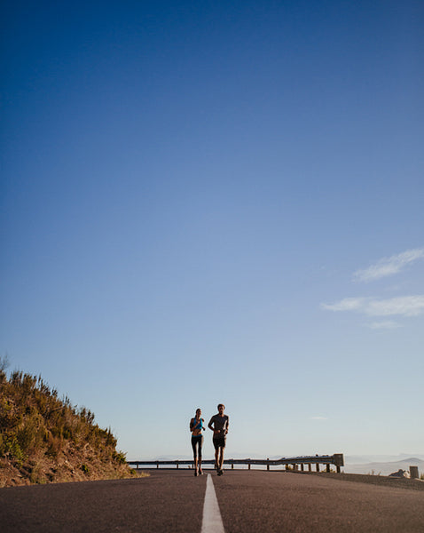 Two young runners running on open country road