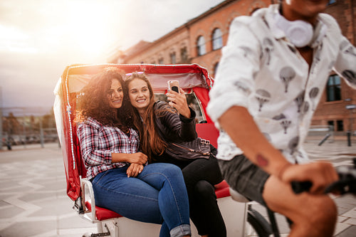 Women friends taking selfie on tricycle ride