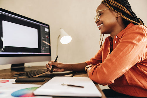 Cheerful female designer working at her desk