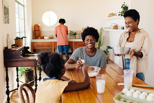 Mom baking with her children in the kitchen, making a pão de queijo recipe