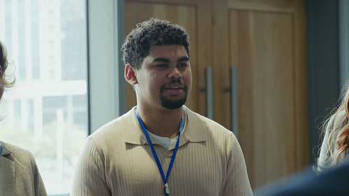 Young professional man smiling and engaging in conversation at a business event