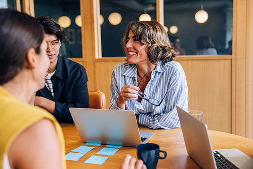 Smiling colleagues discussing ideas in a casual meeting atmosphere
