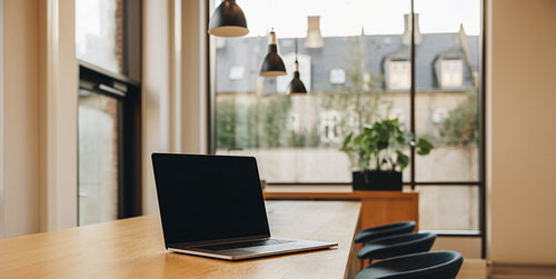 Laptop with black screen on conference table