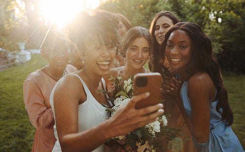 Group of joyful women taking a selfie together during a wedding celebration