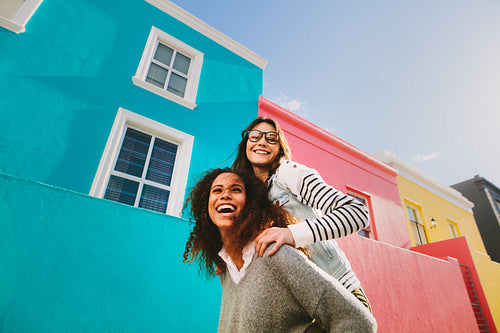Best friends piggybacking and enjoying together