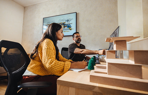 Young professionals collaborating on architectural designs at a small creative studio