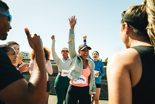 Group of friends cheering after completing a marathon together
