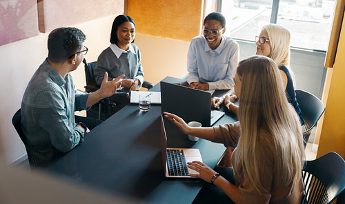 Team meeting with diverse professionals discussing ideas in a modern workspace