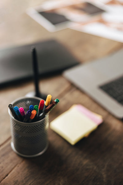 Colour pencils and photographic equipment on a desk