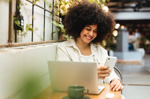 Woman using a phone to make a video call on her coffee break