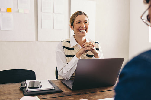 Happy hiring manager interviewing a job candidate in her office