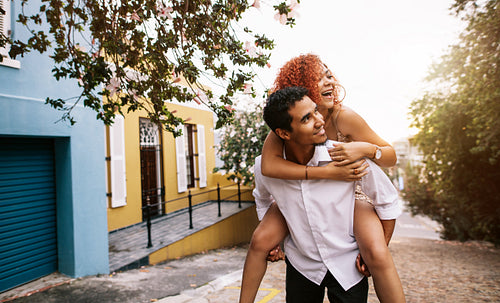 Young couple in a playful having fun in the street.