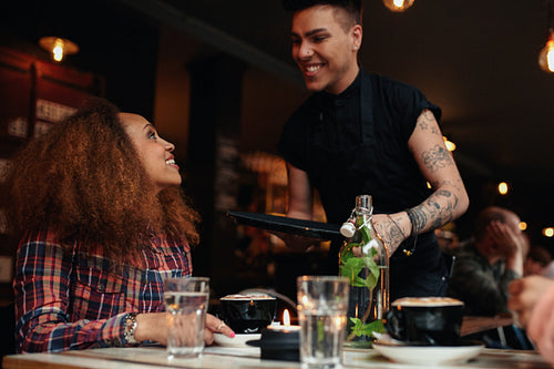 Woman talking to waiter at cafe