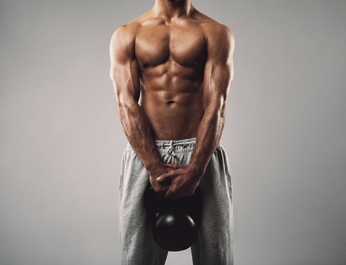 Masculine young man holding kettle bell