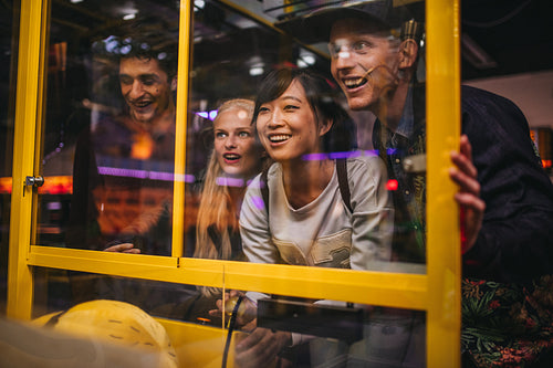 Friends playing toy grabbing game at amusement park