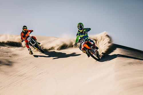 Motocross racers speeding in desert